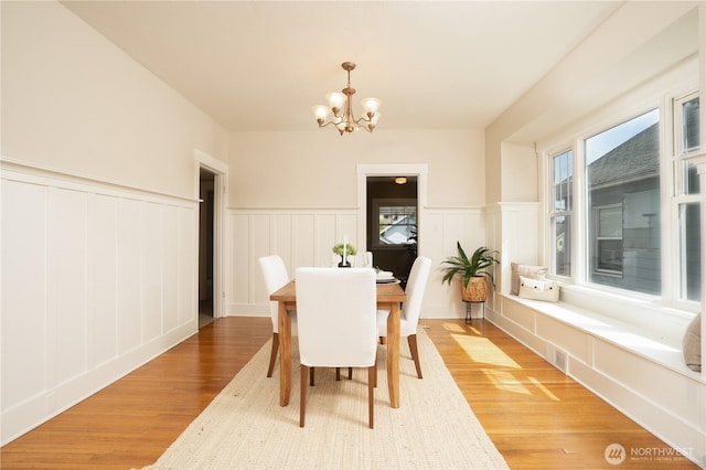 3207 N 9th St, Tacoma, WA 98406 - dining room with a chandelier, a decorative wall, light wood-type flooring, and a wainscoted wall