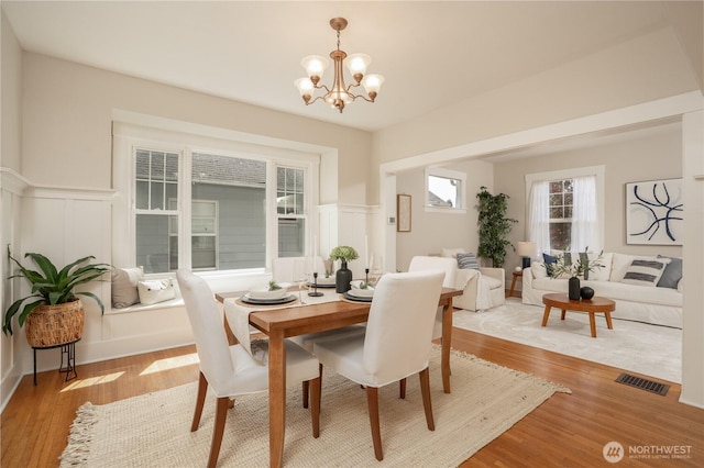 3207 N 9th St, Tacoma, WA 98406 - dining space featuring a chandelier, light wood-type flooring, wainscoting, and a decorative wall