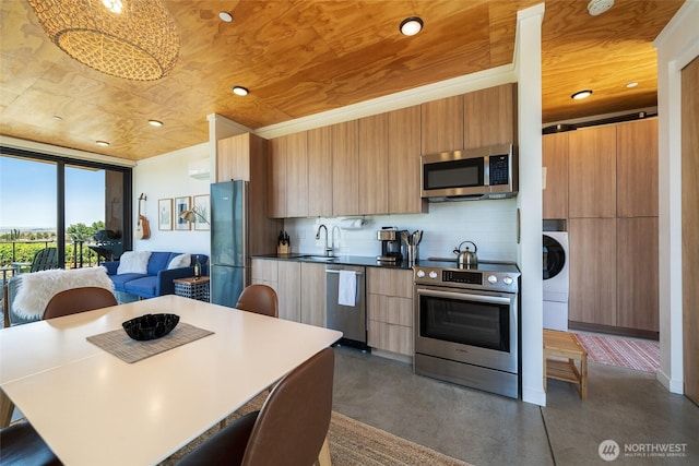23648 Cliffe Pointe Rd NW Unit 10C, Quincy, WA 98848 - kitchen with appliances with stainless steel finishes, modern cabinets, washer / clothes dryer, concrete floors, and a wall of windows