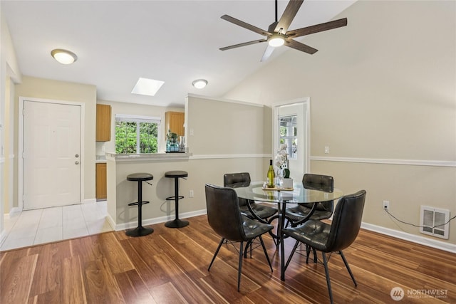 13145 102nd Ln NE Unit 6, Kirkland, WA 98034 - dining room featuring a skylight, light wood-type flooring, a ceiling fan, and vaulted ceiling