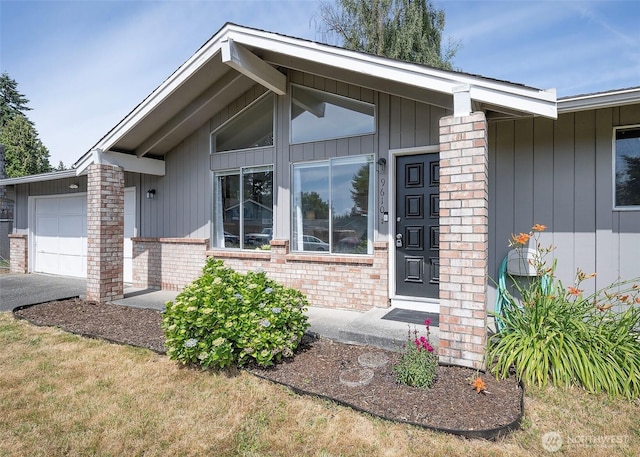 9610 Belmont Dr, Everett, WA 98208 - doorway to property featuring an attached garage, brick siding, and asphalt driveway