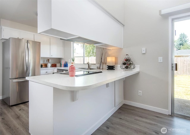 9610 Belmont Dr, Everett, WA 98208 - kitchen with freestanding refrigerator, light wood-style flooring, a peninsula, and light countertops