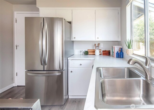 9610 Belmont Dr, Everett, WA 98208 - kitchen featuring freestanding refrigerator, light countertops, white cabinetry, and wood finished floors