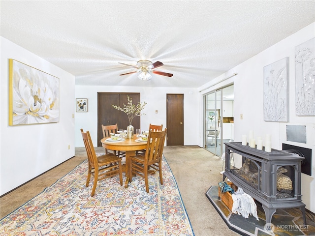 5511 Chokecherry Cir W, University Place, WA 98467 - dining space with light carpet, a wood stove, ceiling fan, and a textured ceiling