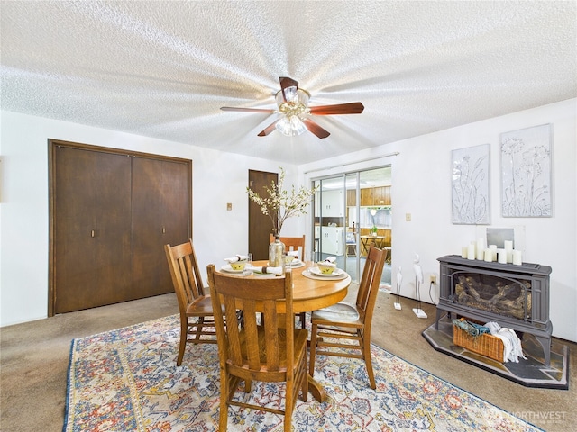 5511 Chokecherry Cir W, University Place, WA 98467 - dining room with a wood stove, a ceiling fan, a textured ceiling, and carpet