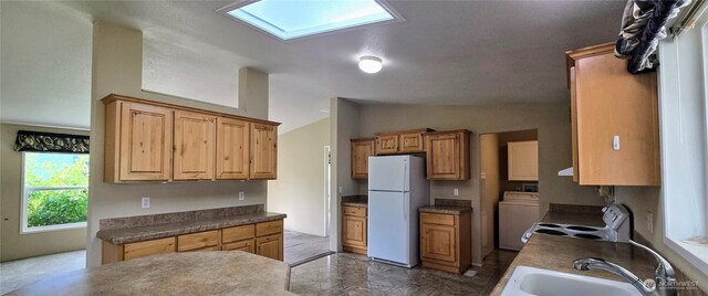 57 Clemons Rd Unit 17, Montesano, WA 98563 - kitchen featuring white appliances, washer / clothes dryer, lofted ceiling, dark countertops, and a skylight