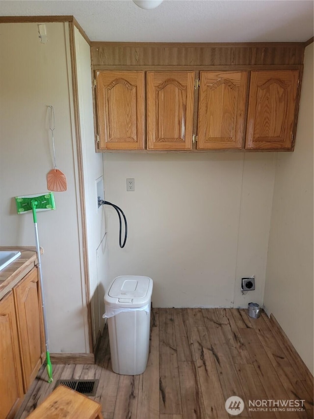 1502 Yelm Ave W Unit 7, Yelm, WA 98597 - laundry room featuring hookup for a washing machine, cabinet space, light wood-style flooring, and hookup for an electric dryer