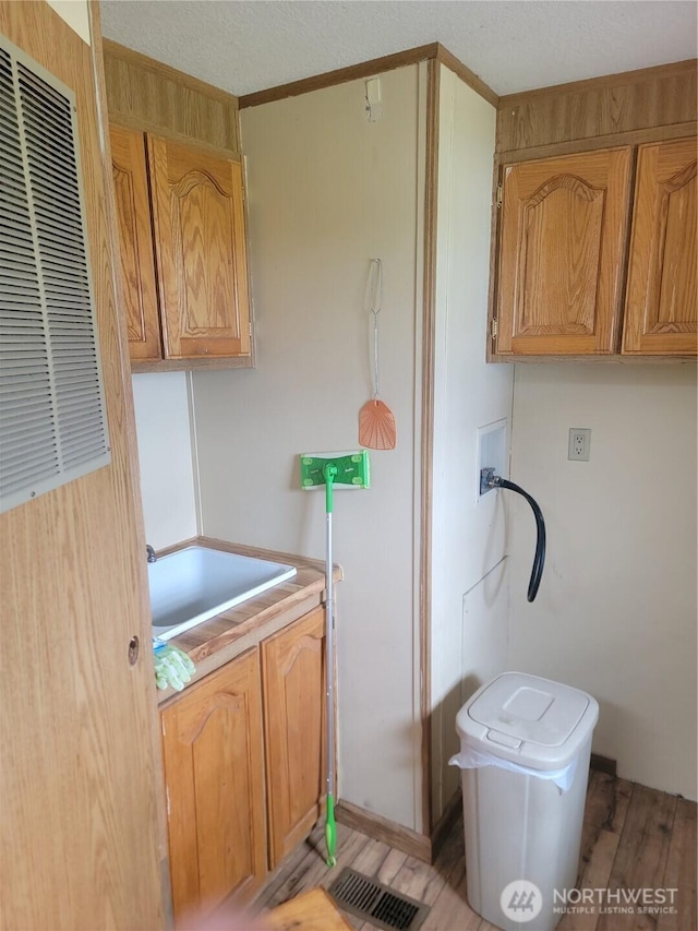 1502 Yelm Ave W Unit 7, Yelm, WA 98597 - kitchen featuring a heating unit, light wood-style floors, a textured ceiling, and light countertops