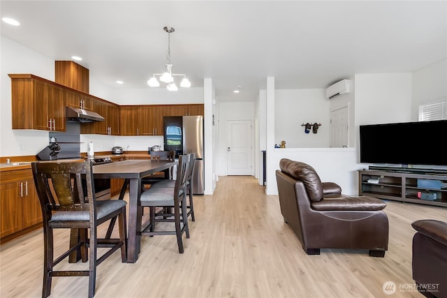 990 43rd Ct NE, Auburn, WA 98002 - kitchen with under cabinet range hood, a wall mounted AC, appliances with stainless steel finishes, a chandelier, and light wood-style flooring