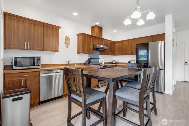 990 43rd Ct NE, Auburn, WA 98002 - kitchen with appliances with stainless steel finishes, under cabinet range hood, light wood-style flooring, recessed lighting, and light countertops