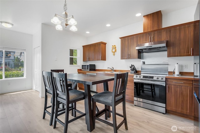 990 43rd Ct NE, Auburn, WA 98002 - kitchen with under cabinet range hood, appliances with stainless steel finishes, light wood-style floors, a chandelier, and recessed lighting