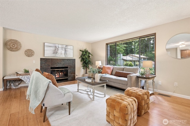 8524 46th Ct NE, Olympia, WA 98516 - living room featuring light wood-style flooring, a premium fireplace, and a textured ceiling