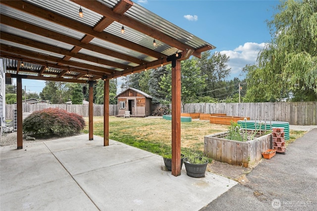 611 Elizabeth St, Sumner, WA 98390 - fenced backyard featuring a patio area, a vegetable garden, and an outdoor structure