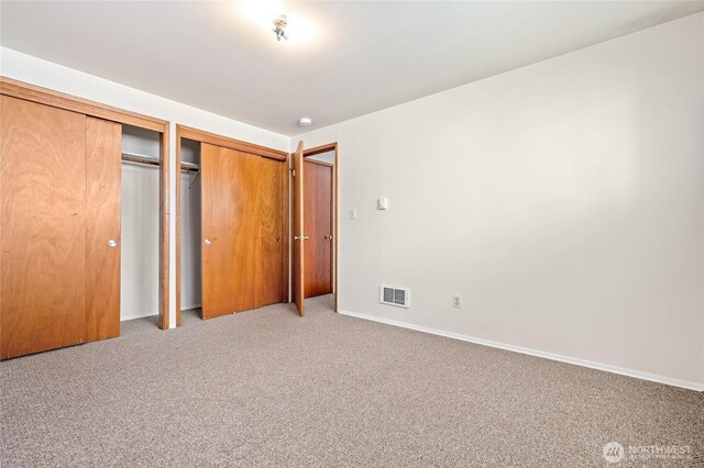 633 W Emerson St, Seattle, WA 98119 - unfurnished bedroom featuring carpet floors and multiple closets