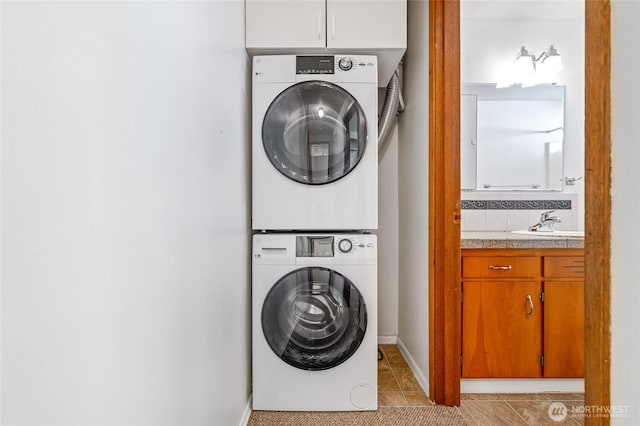 633 W Emerson St, Seattle, WA 98119 - laundry room with stacked washing machine and dryer, tile patterned flooring, and cabinet space