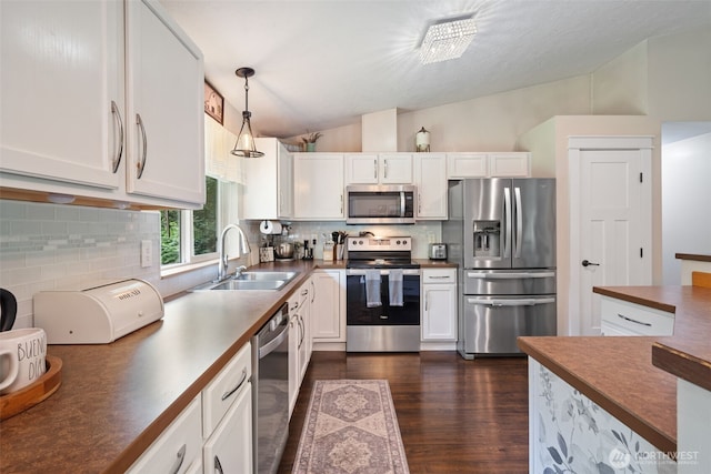 130 Kimberlund Ln, Chehalis, WA 98532 - kitchen with appliances with stainless steel finishes, vaulted ceiling, white cabinetry, backsplash, and dark wood-style floors