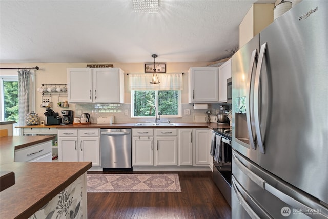 130 Kimberlund Ln, Chehalis, WA 98532 - kitchen with stainless steel appliances, dark wood-type flooring, decorative backsplash, white cabinetry, and a textured ceiling