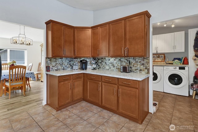 2610 E Section St Unit 25, Mount Vernon, WA 98274 - kitchen with separate washer and dryer, a chandelier, brown cabinets, and tasteful backsplash