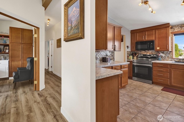 2610 E Section St Unit 25, Mount Vernon, WA 98274 - kitchen featuring stainless steel range with electric cooktop, black microwave, tasteful backsplash, lofted ceiling, and light countertops