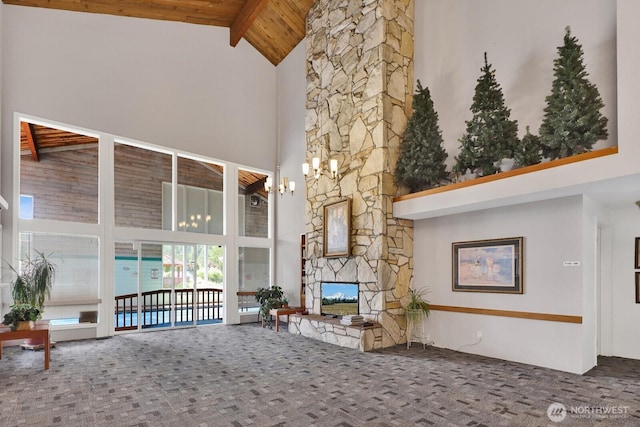 2610 E Section St Unit 25, Mount Vernon, WA 98274 - living area featuring high vaulted ceiling, a wooden ceiling with exposed beams, carpet, and a stone fireplace