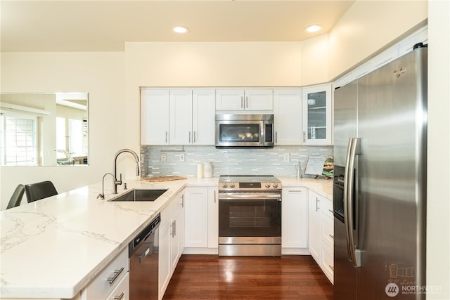 18630 NE 57th Way, Redmond, WA 98052 - kitchen featuring stainless steel appliances, a peninsula, light stone countertops, backsplash, and dark wood finished floors