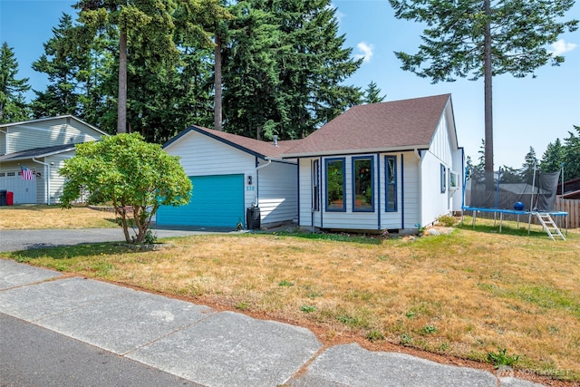 538 NW Ensign Dr, Oak Harbor, WA 98277 - view of front of property featuring a trampoline, an attached garage, a front yard, driveway, and a shingled roof