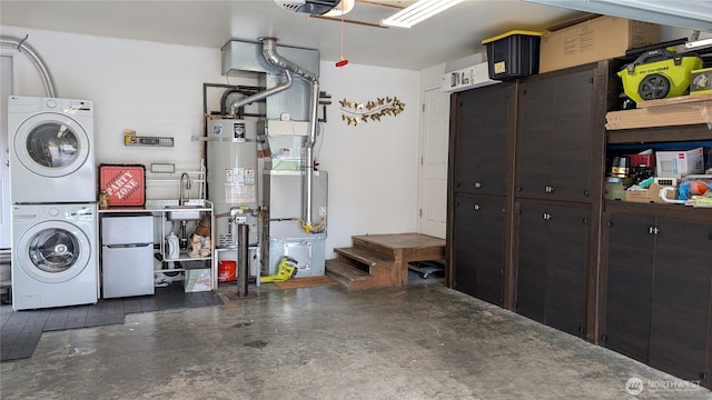 538 NW Ensign Dr, Oak Harbor, WA 98277 - garage with estacked washer and dryer, secured water heater, refrigerator, a garage door opener, and heating unit