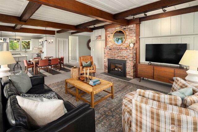 14830 Glen Acres Rd SW, Vashon, WA 98070 - carpeted living area featuring beamed ceiling, a chandelier, and a brick fireplace