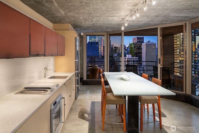 2125 1st Ave Unit 3003, Seattle, WA 98121 - kitchen with concrete floors, stovetop, a view of skyline, light countertops, and wall oven