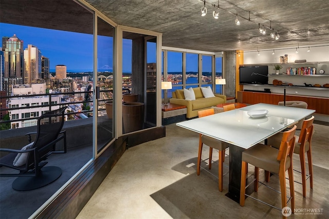 2125 1st Ave Unit 3003, Seattle, WA 98121 - dining room with concrete flooring, a view of city, track lighting, and a wall of windows