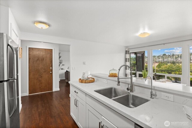 2636 22nd Ave W Unit 101, Seattle, WA 98199 - kitchen featuring freestanding refrigerator, dark wood-style flooring, and white cabinetry