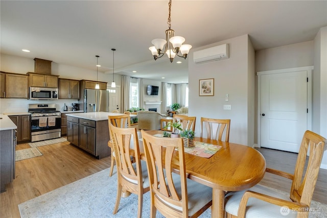 103N Trail Rd, Sedro Woolley, WA 98284 - dining area with a wall mounted AC, light wood-style flooring, a chandelier, a fireplace, and recessed lighting