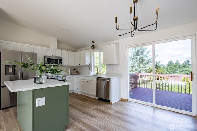 7801 144th Street Ct E, Puyallup, WA 98375 - kitchen with stainless steel appliances, lofted ceiling, light countertops, a kitchen island, and white cabinets