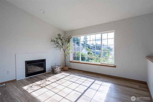 7801 144th Street Ct E, Puyallup, WA 98375 - unfurnished living room with wood finished floors, a fireplace, and vaulted ceiling