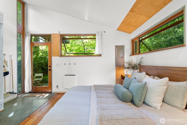 11230 Asta Ln SW, Vashon, WA 98070 - bedroom featuring vaulted ceiling, multiple windows, hardwood / wood-style floors, access to outside, and radiator