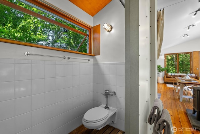11230 Asta Ln SW, Vashon, WA 98070 - bathroom featuring tile walls, wood-type flooring, vaulted ceiling, and a wainscoted wall