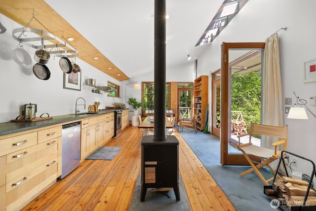 11230 Asta Ln SW, Vashon, WA 98070 - kitchen featuring stainless steel appliances, light brown cabinetry, light wood-style flooring, dark countertops, and lofted ceiling