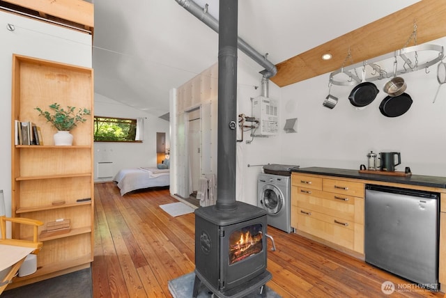 11230 Asta Ln SW, Vashon, WA 98070 - bar area with washer / clothes dryer, a wood stove, refrigerator, vaulted ceiling, and hardwood / wood-style flooring