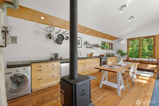 11230 Asta Ln SW, Vashon, WA 98070 - dining area featuring washer / dryer, light wood finished floors, a wood stove, and vaulted ceiling