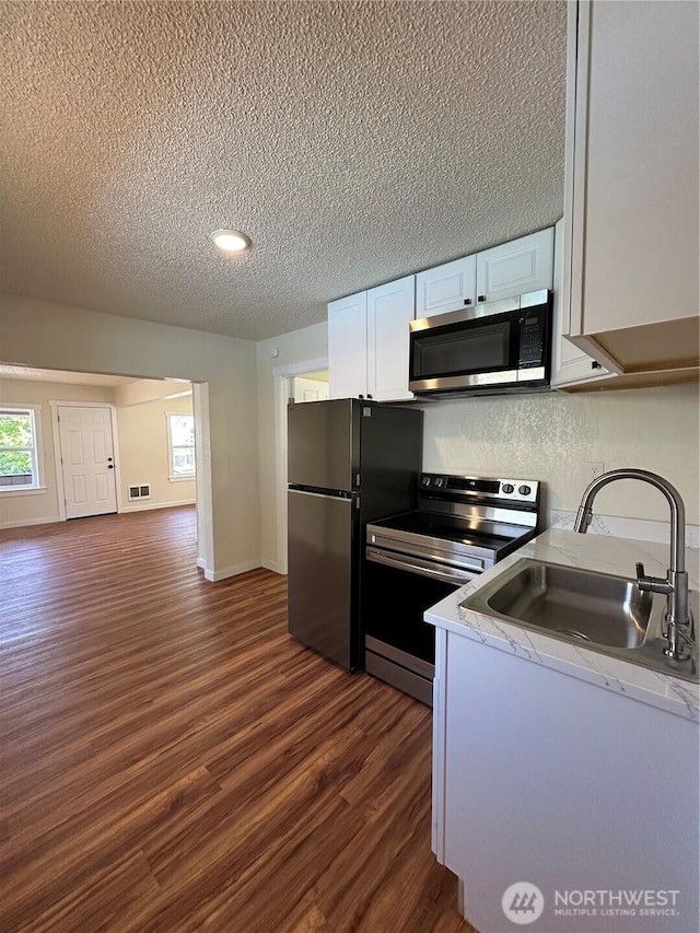 836 S Cashmere St, Wenatchee, WA 98801 - kitchen with stainless steel appliances, dark wood-style flooring, a textured ceiling, white cabinets, and light countertops