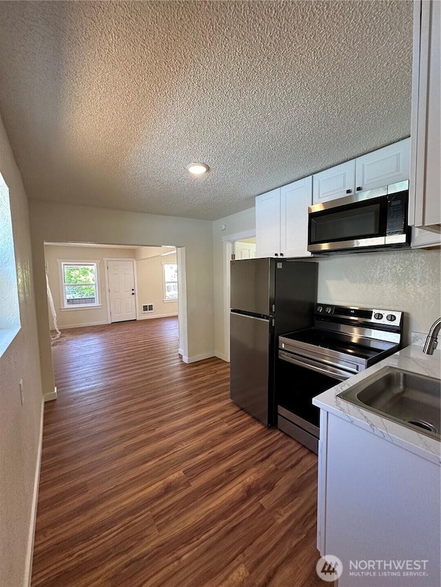 836 S Cashmere St, Wenatchee, WA 98801 - kitchen with stainless steel appliances, dark wood-type flooring, a textured ceiling, white cabinetry, and light countertops