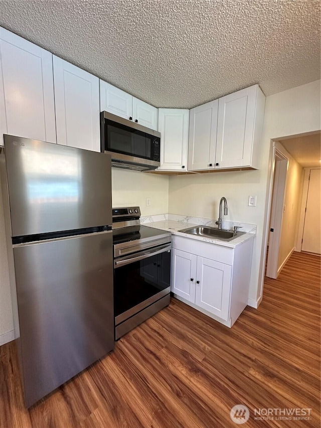 836 S Cashmere St, Wenatchee, WA 98801 - kitchen featuring appliances with stainless steel finishes, dark wood-style floors, white cabinets, light countertops, and a textured ceiling