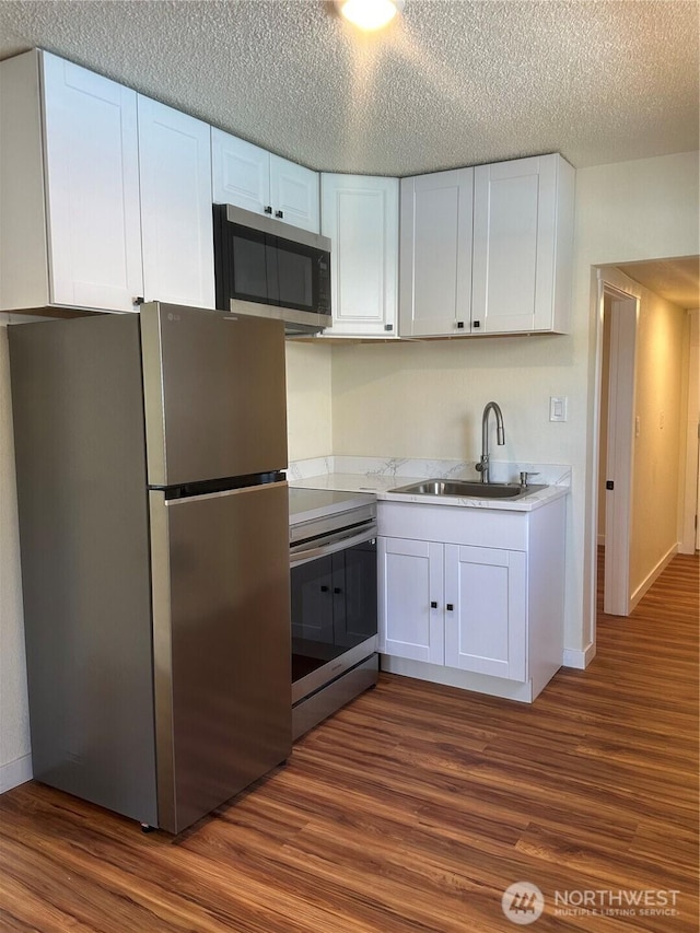 836 S Cashmere St, Wenatchee, WA 98801 - kitchen featuring stainless steel appliances, white cabinetry, dark wood-style floors, light countertops, and a textured ceiling