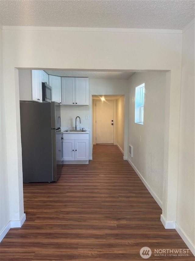 836 S Cashmere St, Wenatchee, WA 98801 - kitchen with appliances with stainless steel finishes, dark wood-type flooring, white cabinetry, ornamental molding, and a textured ceiling