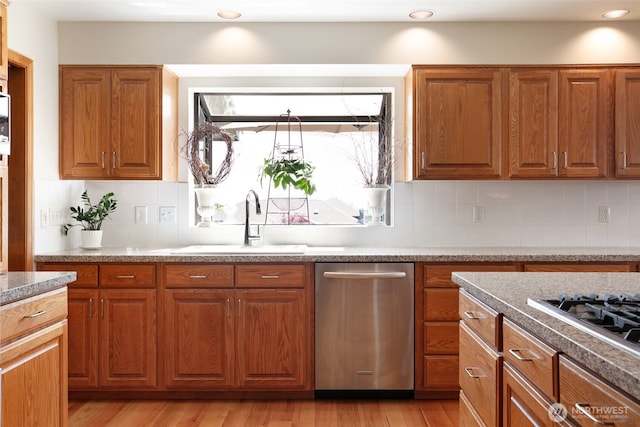 7610 Scenic Dr, Yakima, WA 98908 - kitchen featuring stainless steel appliances, brown cabinetry, light wood-type flooring, and tasteful backsplash