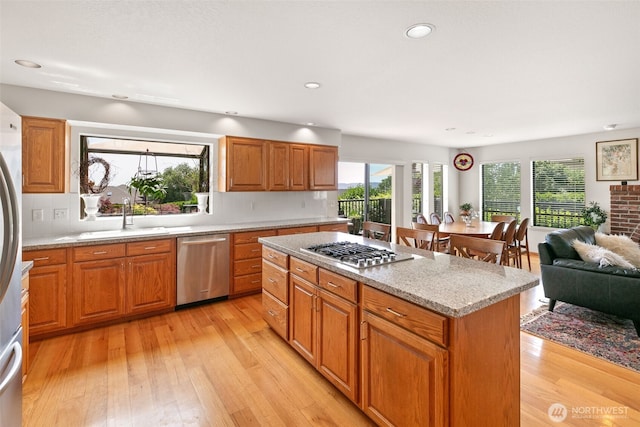 7610 Scenic Dr, Yakima, WA 98908 - kitchen with stainless steel appliances, light wood finished floors, a kitchen island, light stone countertops, and recessed lighting