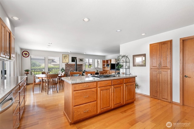 7610 Scenic Dr, Yakima, WA 98908 - kitchen with light wood-style flooring, appliances with stainless steel finishes, recessed lighting, a center island, and light stone countertops