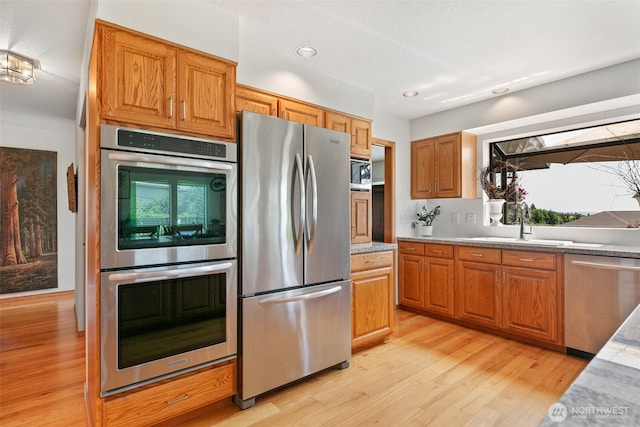 7610 Scenic Dr, Yakima, WA 98908 - kitchen featuring stainless steel appliances, light wood-type flooring, light countertops, recessed lighting, and brown cabinetry