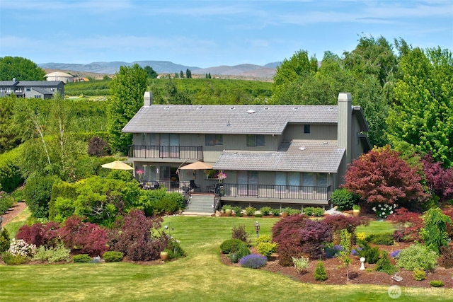 7610 Scenic Dr, Yakima, WA 98908 - back of property featuring a chimney, a balcony, a lawn, and a deck with mountain view