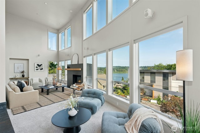 8812 NE 117th Pl, Kirkland, WA 98034 - living room featuring a water view, a towering ceiling, and a lit fireplace